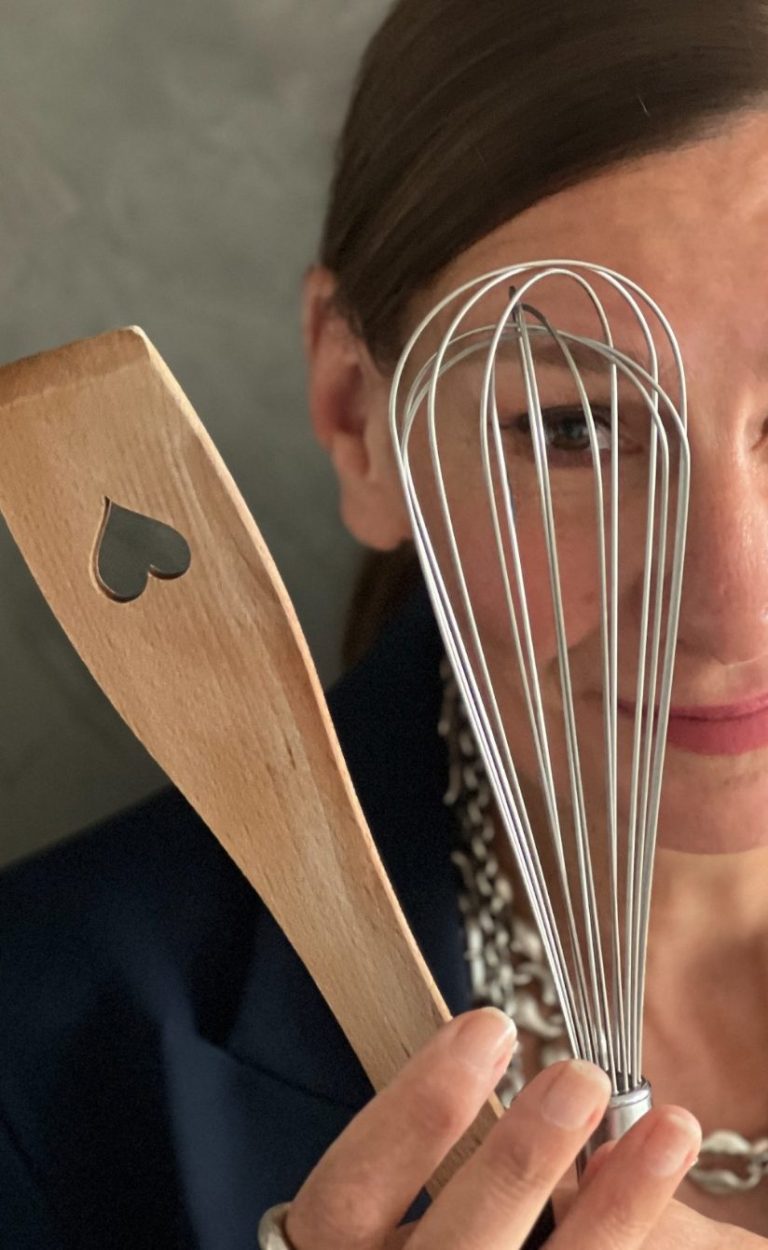 Online-Stilberatung: Keine Regeln, nur Rezepte. Keine Regeln, nur Rezepte. Ellen Schmitt hält einen Holzspatel mit Herz und einen Schneebesen in der Hand.